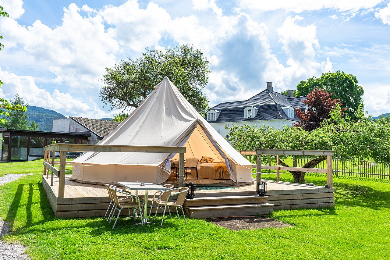 Glamping-Zelt mit Bett und Möbeln: Komfort statt Isomatte. Bild: JLunder96, Wikimedia Commons, CC BY 4.0